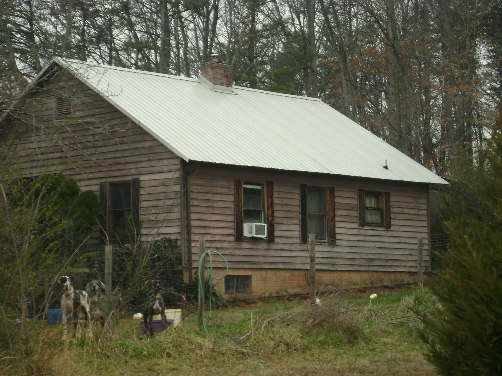White metal roof on an old wood sided farmhouse, from a Metal Roof Installation job in Howard